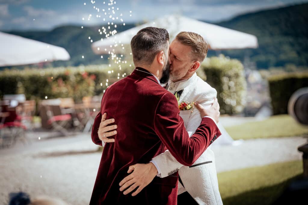 lgbtq hochzeit auf der sich die Bräutigame küssen