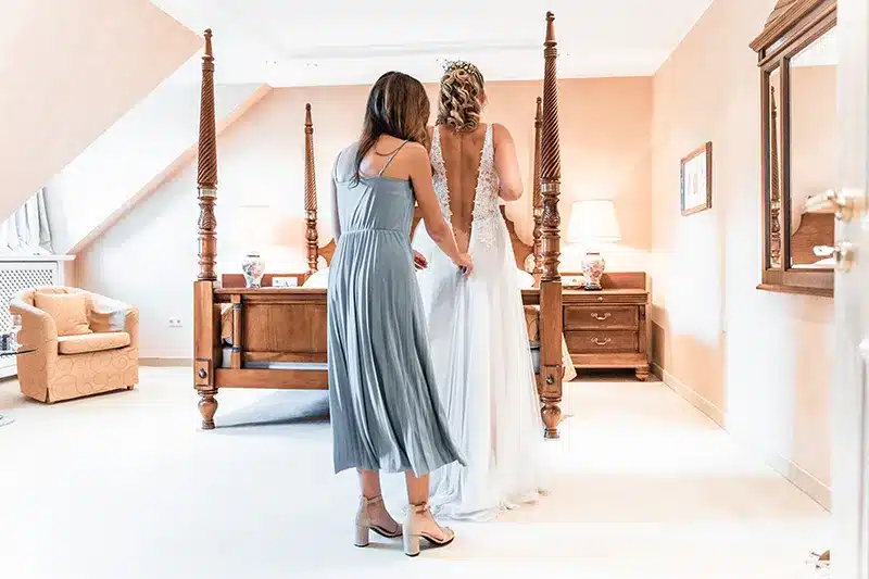 Braut im Brautkleid mit Trauzeugin beim Getting Ready